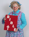 Rainbow the Clown holding an oversized Bible