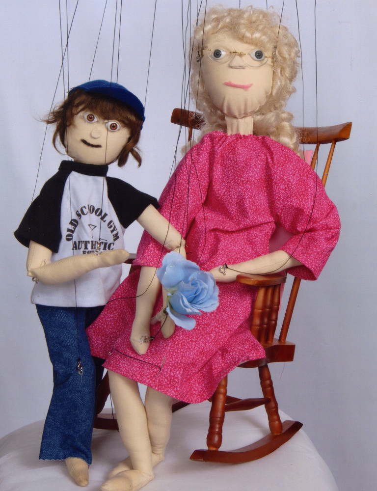 Two marionettes, one an old lady in a rocking chair