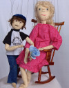 Two marionettes, one an old lady in a rocking chair