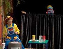 Rainbow plays a drum while a puppet sings