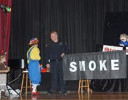 Rainbow talks to a fire fighter holding a banner that reads "smoke"