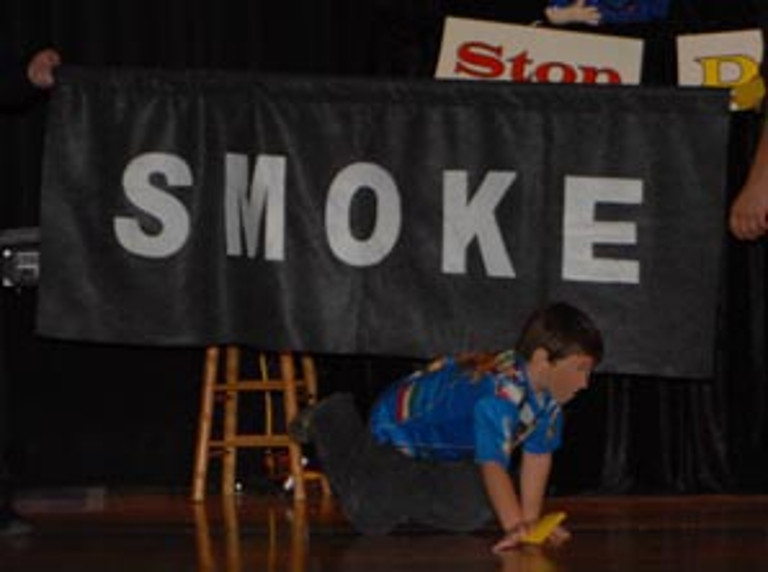 A child crawls under smoke
